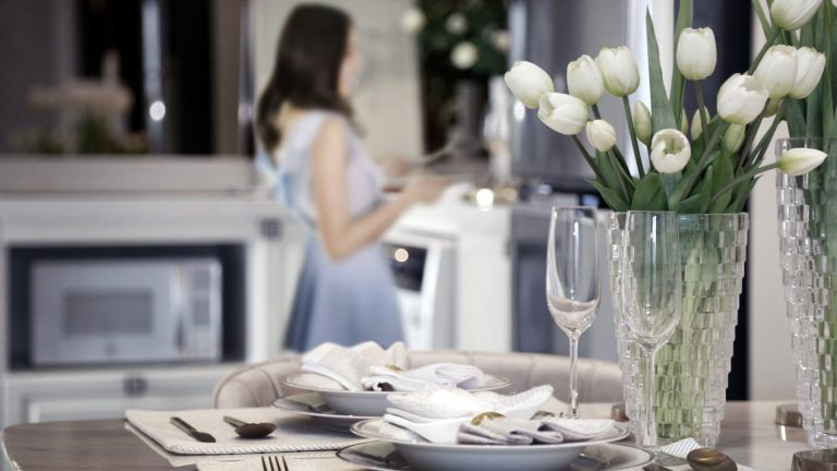 woman-preparing-dishware-romantic-dinner-table